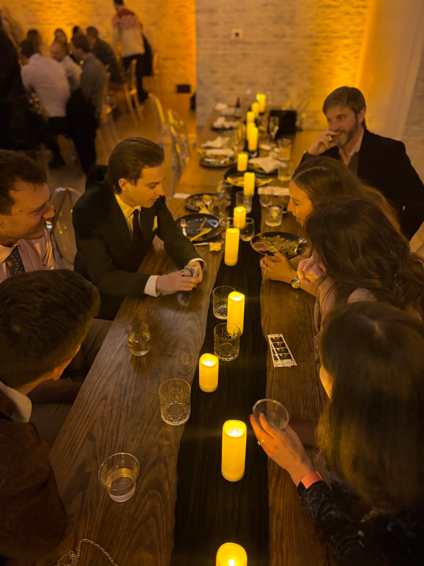Griffin performing close-up magic at a candlelit corporate dinner table